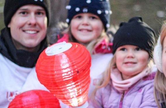 Family of 4 taking a picture with a Light The Night lantern