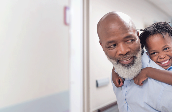 An old man giving a piggy-back to his grandson