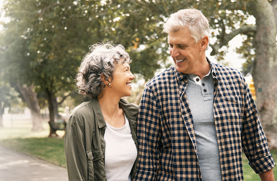 Man and woman holding hands and smiling at each other.
