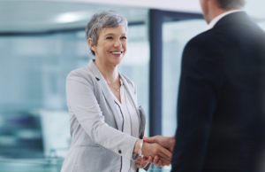 An employer and their employee shaking hands.