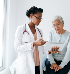 A Woman with doctor looking over test results.