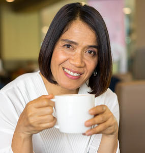 Woman smiling with a coffee cup in her hands