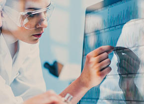 Two people analyzing charts on a computer screen