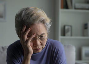 old woman holding her head