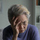 old woman holding her head