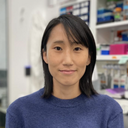 Holly Lee sits in front of a shelf 